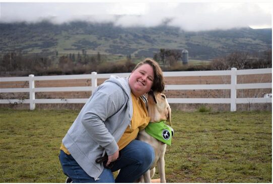 Kelly and his trainer. She is kneeling down and Kelly is kissing her face.